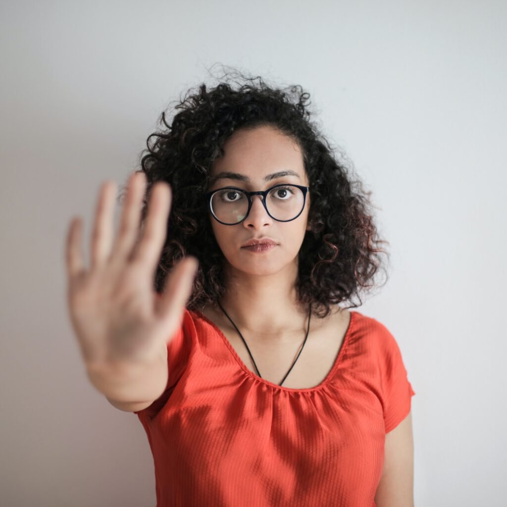 Photo by Andrea Piacquadio: https://www.pexels.com/photo/portrait-photo-of-woman-in-red-top-wearing-black-framed-eyeglasses-holding-out-her-hand-in-stop-gesture-3762802/